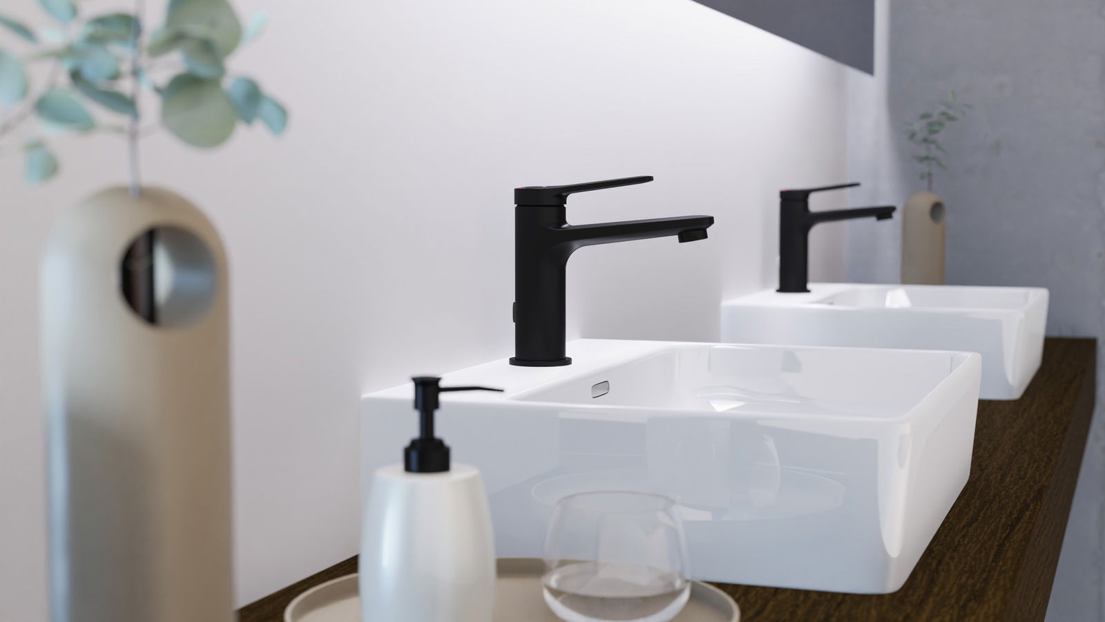 Moderne schwarze Waschtischarmatur in seitlicher Perspektive auf einem weißen Waschbecken, umgeben von minimalistischen Badezimmeraccessoires.