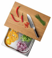 Multifunktionsbrett mit Schublade, darauf rote Chilischoten, ein Messer und Schnittlauch, darunter geschnittenes Gemüse in einer Edelstahlschale, aus der Vogelperspektive.