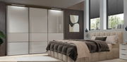 Moderner Schwebetürenschrank mit drei Türen in einem stilvollen Schlafzimmer, seitliche Perspektive.