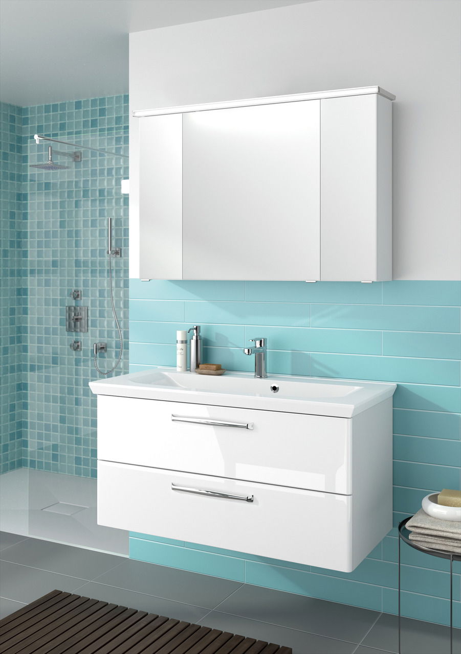 Moderner weißer Badblock mit zwei Schubladen und integriertem Waschbecken, montiert vor einer türkisfarbenen Wand. Perspektive von vorne.