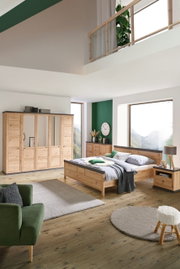 Holzbett 180x200 in einem modernen Schlafzimmer mit grünen Akzenten, seitliche Perspektive