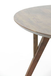 Nahaufnahme eines runden Esstisches aus Holz mit schrägen Beinen, Perspektive von der Seite.