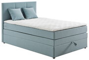Boxspringbed met lichtblauwe bekleding en twee kussens, zijaanzicht