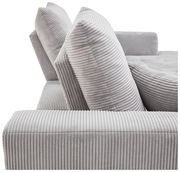 Nahaufnahme einer grauen, gerippten Sofaecke mit zwei großen Kissen, seitliche Perspektive.