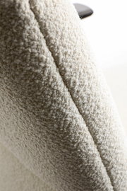 Nahaufnahme einer cremefarbenen Teddyfleece-Oberfläche mit weicher, noppiger Struktur; Perspektive: Detailaufnahme/Close-up schräg von der Seite.