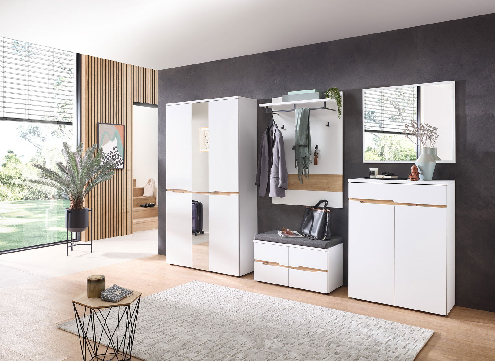 Moderne Garderobeneinrichtung mit weißem Schrank, Spiegel, Garderobenpaneel und Sitzbank in einem stilvollen Raum, seitliche Perspektive.