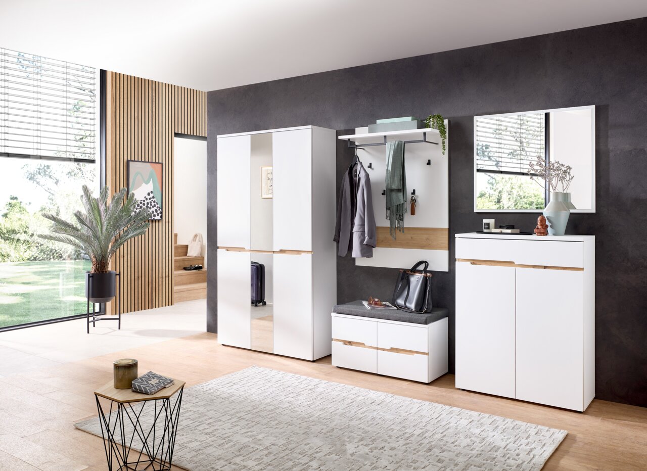 Moderne garderobe-inrichting met witte kast, spiegel, garderobepaneel en bankje in een stijlvolle ruimte, gezien vanuit de zijkant.