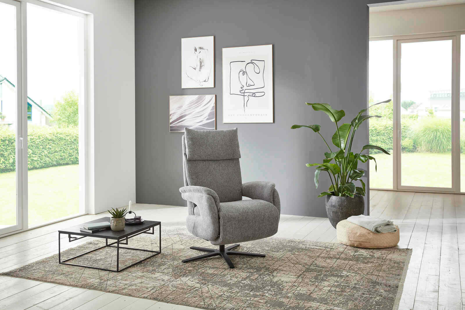 Grauer Fernsehsessel in einem modernen Wohnzimmer, seitliche Perspektive.