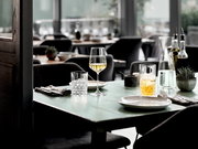 Elegantes Becherset auf einem gedeckten Tisch in einem stilvollen Restaurant, seitliche Perspektive.