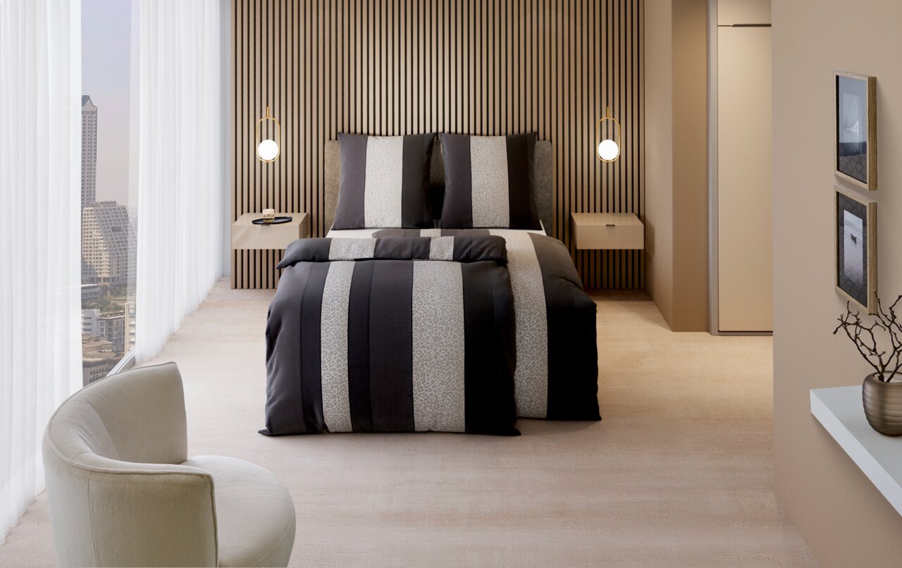 Moderne Bettwäsche in einem stilvollen Schlafzimmer mit Streifenmuster in Grau- und Beigetönen, frontal aufgenommen.