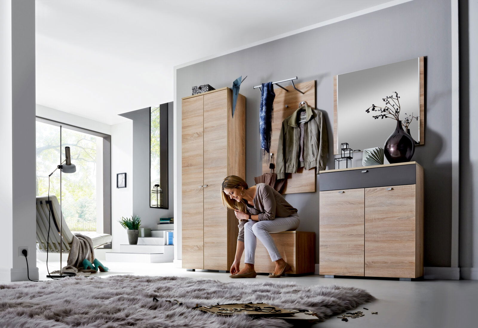 Moderne Garderobenkombination in Holzoptik mit Spiegel, Kleiderhaken und Stauraum, seitliche Perspektive.