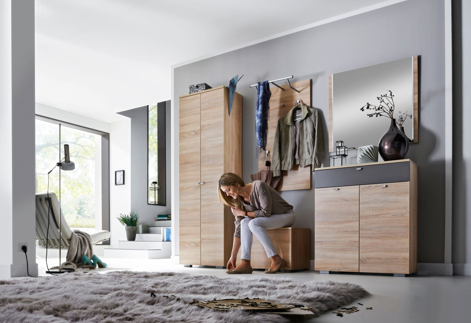 Moderne Garderobenkombination in Holzoptik mit Spiegel, Kleiderhaken und Stauraum, seitliche Perspektive.