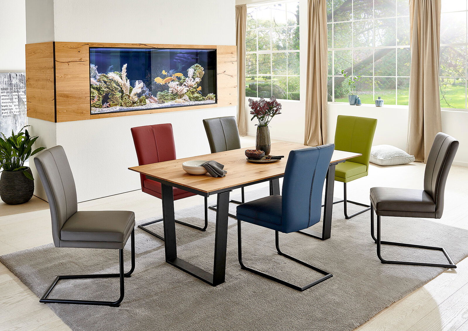 Esszimmer mit modernem Freischwinger-Stuhl-Set in verschiedenen Farben um einen Holztisch, seitliche Perspektive.