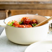Gusseiserner Bräter in Mandelweiß mit Fleischbällchen in Tomatensauce, seitliche Perspektive
