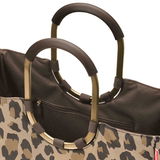 Nahaufnahme einer Tasche mit Leopardenmuster und stabilen, ovalen Griffen aus Metall.