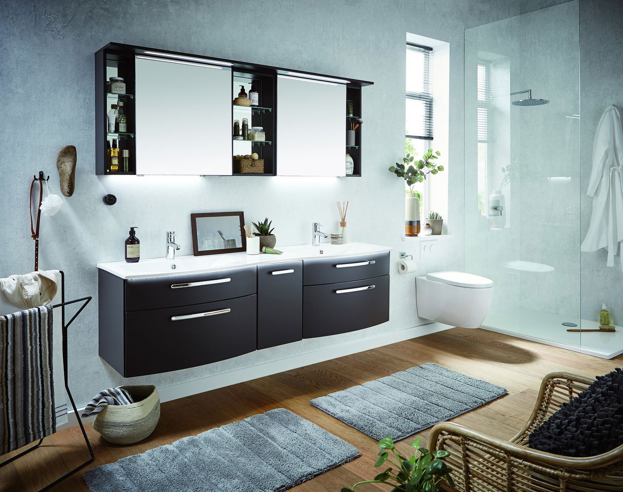 Moderne Badkombination mit Doppelwaschbecken, dunklen Schränken und Spiegeln, seitliche Perspektive