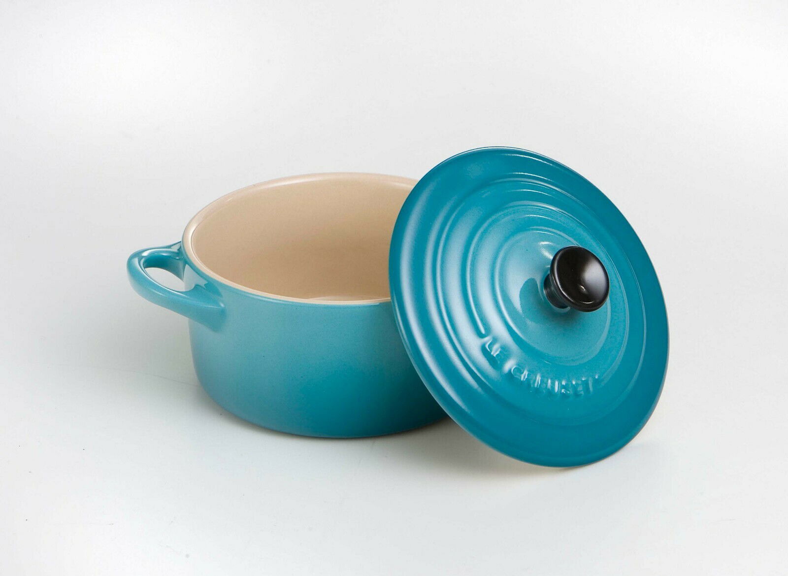 Offene Mini-Cocotte in Karibikblau mit abgenommenem Deckel, seitliche Perspektive