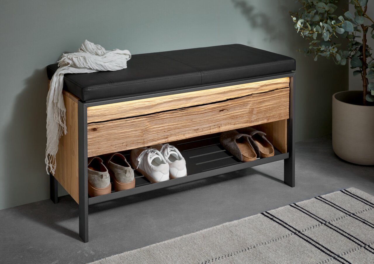 Garderobenbank mit schwarzem Sitzpolster, Holzfront und Schuhablage, seitliche Perspektive