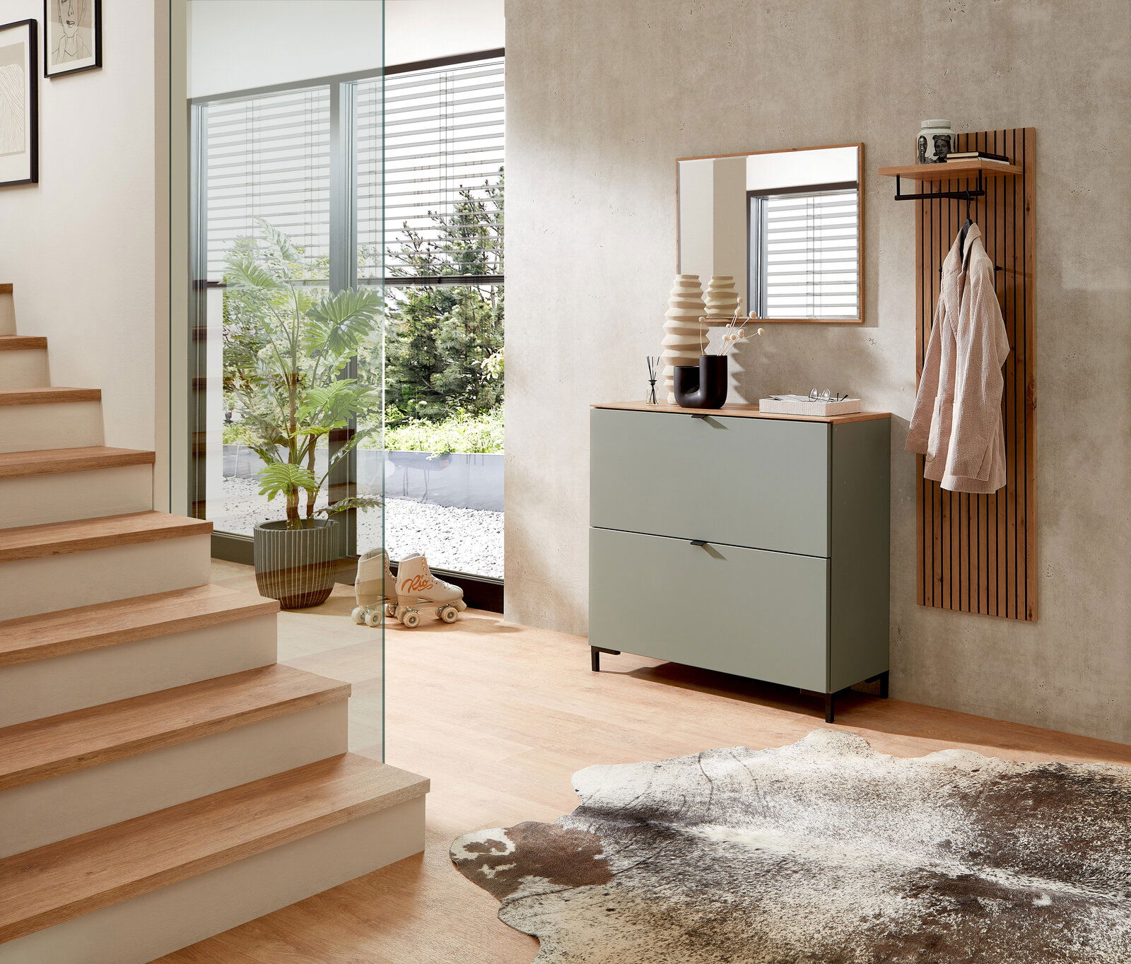 Moderner Eingangsbereich mit grünem Hängeschrank, Spiegel und Garderobenpaneel aus Holz, seitliche Perspektive.