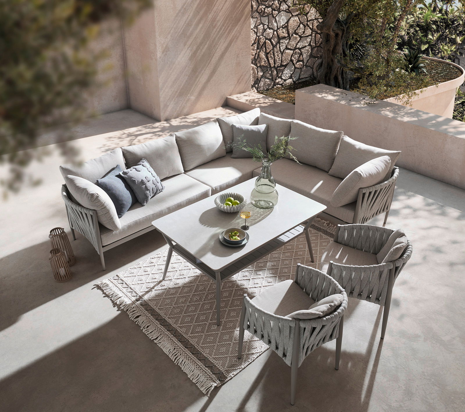 Loungegarnitur in moderner Terrasse, bestehend aus einem Ecksofa, einem Tisch und zwei Sesseln, aus der Vogelperspektive fotografiert.