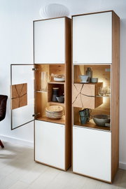 Vitrine Valnatura LAGO met geopende glazen deur, houten en glazen elementen, gezien vanaf de linkerkant.