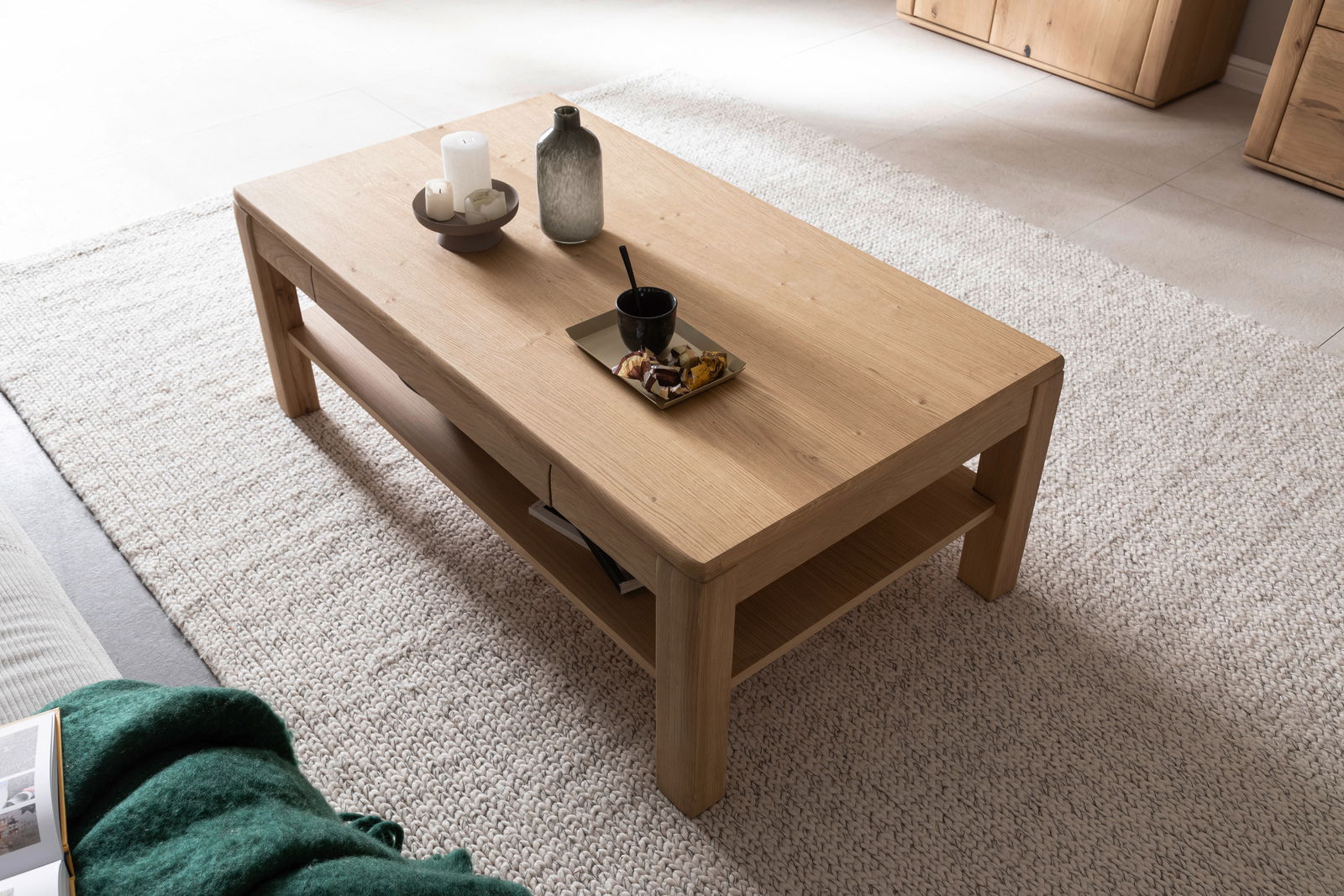 Holz-Couchtisch mit Dekorationen aus der Vogelperspektive, auf einem hellen Teppich stehend.