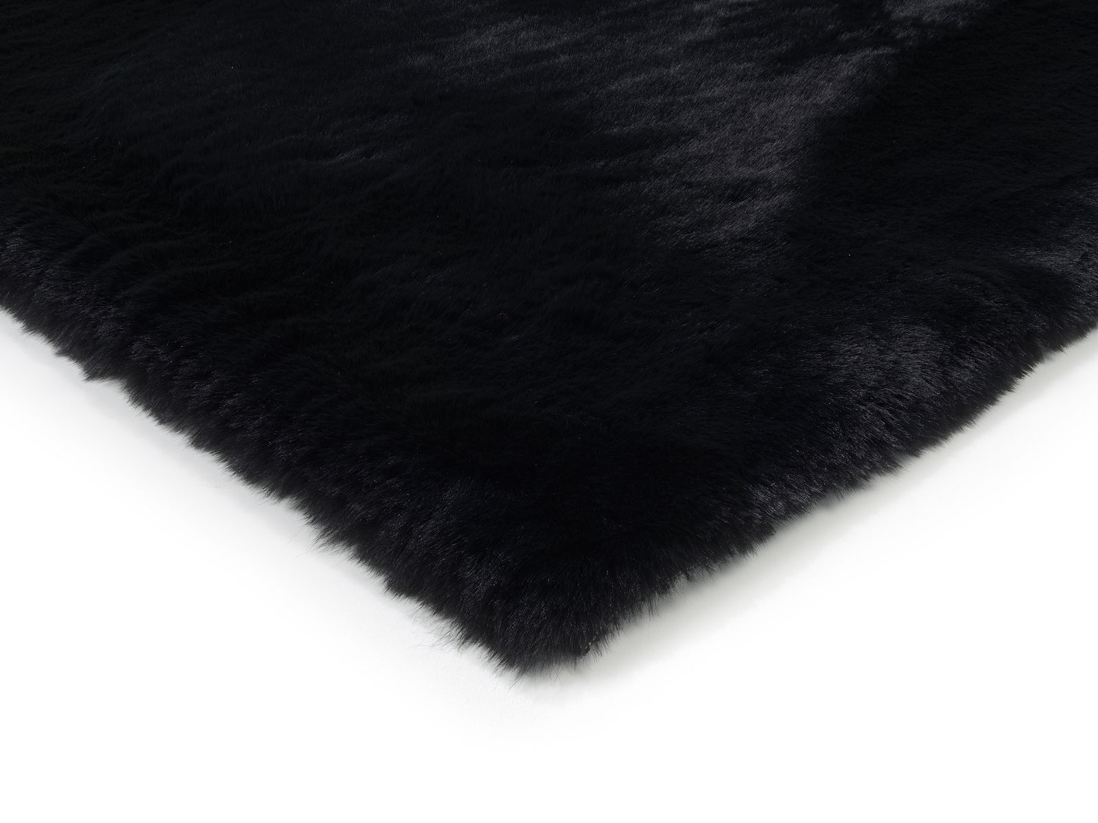 Nahaufnahme eines schwarzen Fellteppichs aus der Seitenperspektive.