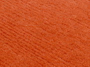 Nahaufnahme eines orangefarbenen Wollteppichs mit weicher Textur.