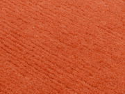Nahaufnahme eines orangefarbenen Wollteppichs mit weicher Textur.