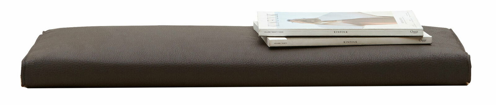 Braunes Sitzkissen der Serie SORRENT von Dieter Knoll, seitliche Perspektive, mit zwei darauf liegenden Zeitschriften.