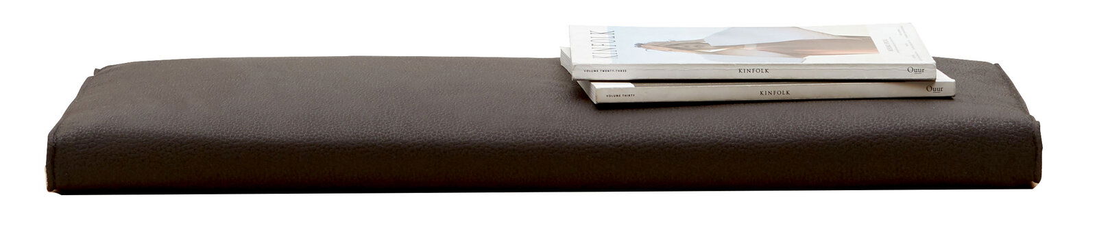 Dieter Knoll Sitzkissen SORRENT Braunes Sitzkissen der Serie SORRENT von Dieter Knoll, seitliche Perspektive, mit zwei darauf liegenden Zeitschriften.