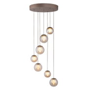 Moderne LED-Pendelleuchte mit sieben kugelförmigen Lampen, die in einer eleganten, absteigenden Anordnung von einer runden Deckenhalterung hängen. Seitenansicht.