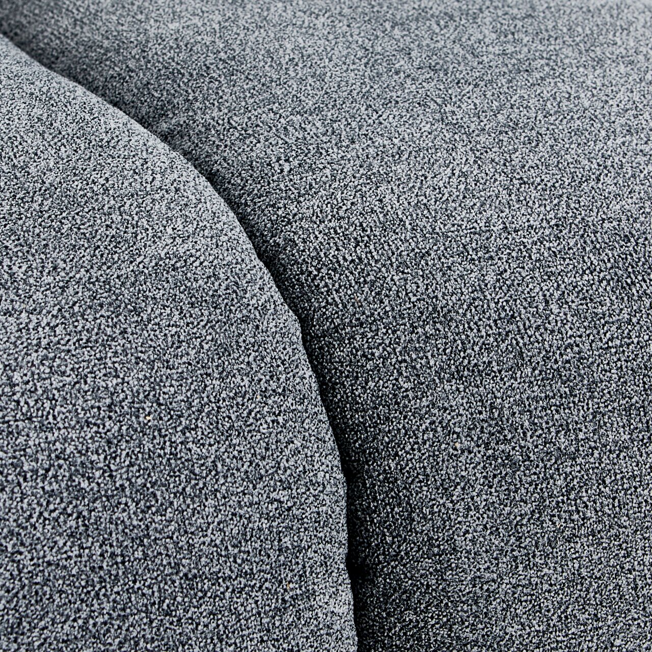 Nahaufnahme einer grauen Stoffoberfläche mit texturierter Struktur, perspektivisch von oben betrachtet.