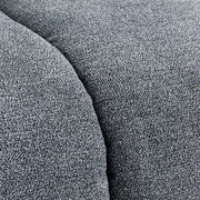 Nahaufnahme einer grauen Stoffoberfläche mit texturierter Struktur, perspektivisch von oben betrachtet.