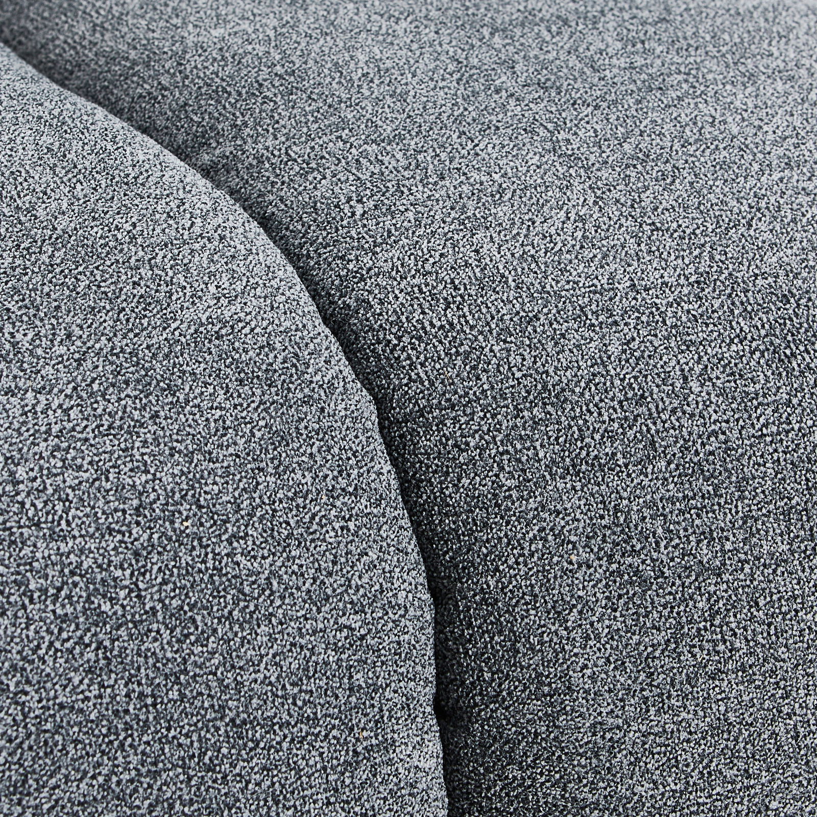 Nahaufnahme einer grauen Stoffoberfläche mit texturierter Struktur, perspektivisch von oben betrachtet.