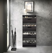Moderner Schuhkipper mit vier Klappen in einem eleganten, dunklen Design, frontal betrachtet, neben einem Schirmständer und einer Tür.