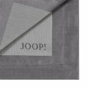 Graue Serviette mit eingewebtem 'JOOP!' Logo, teilweise umgeschlagen, Draufsicht