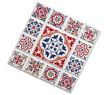 Untersetzer MARRAKESCH Blume mit buntem Mosaikmuster in Rot, Blau und Weiß, schräg von oben fotografiert.