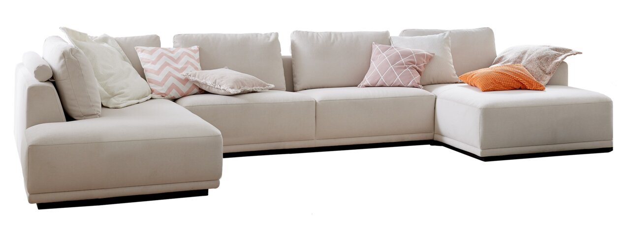 Beige hoekbank met diverse sierkussens, zijaanzicht