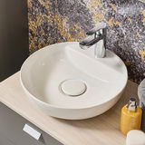 Moderner runder Waschtisch mit glänzendem Wasserhahn, seitliche Perspektive