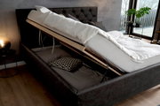 Polsterbett mit hochgeklappter Matratze und Stauraum, seitliche Perspektive