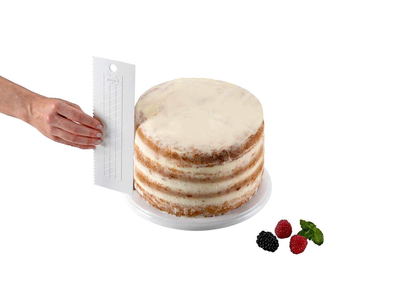 Hand hält einen extra hohen Tortenglätter neben einer mehrschichtigen Torte, seitliche Perspektive.