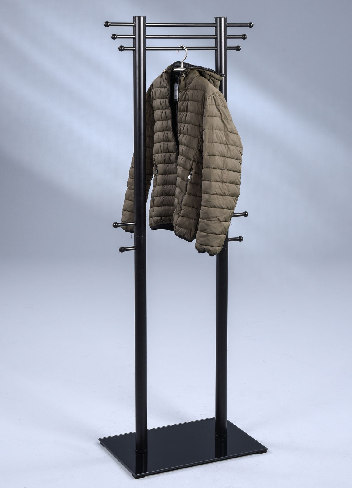 Moderner Kleiderständer aus Metall mit mehreren Haken, frontal fotografiert, mit einer Jacke darauf.