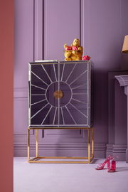 Goldene Gorilla-Dekofigur auf einem modernen, verspiegelten Schrank mit lila Hintergrund, frontal betrachtet.