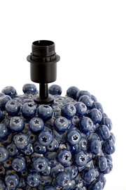 Nahaufnahme eines blauen, kugelförmigen Lampenfußes mit sternförmigen Mustern, aus der Perspektive von oben.