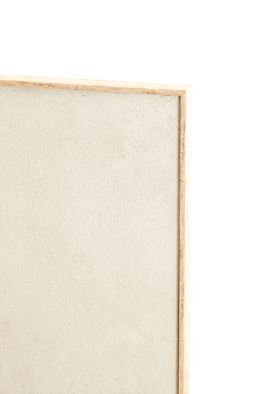 Nahaufnahme eines Wandornaments mit hellem, strukturiertem Hintergrund und einem schmalen Holzrahmen, von der Seite betrachtet.