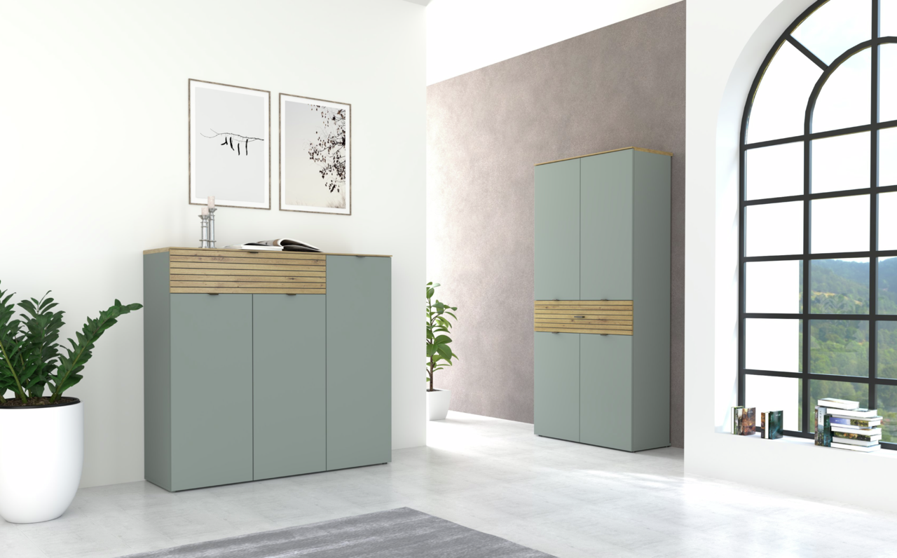 Moderne Garderoben-Sets in einem hellen Raum mit großen Fenstern, bestehend aus einem Sideboard und einem hohen Schrank in Schilfgrün mit Holzakzenten, seitliche Perspektive.