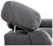 Nahaufnahme einer grauen Kopfstütze eines Sofas aus der seitlichen Perspektive.