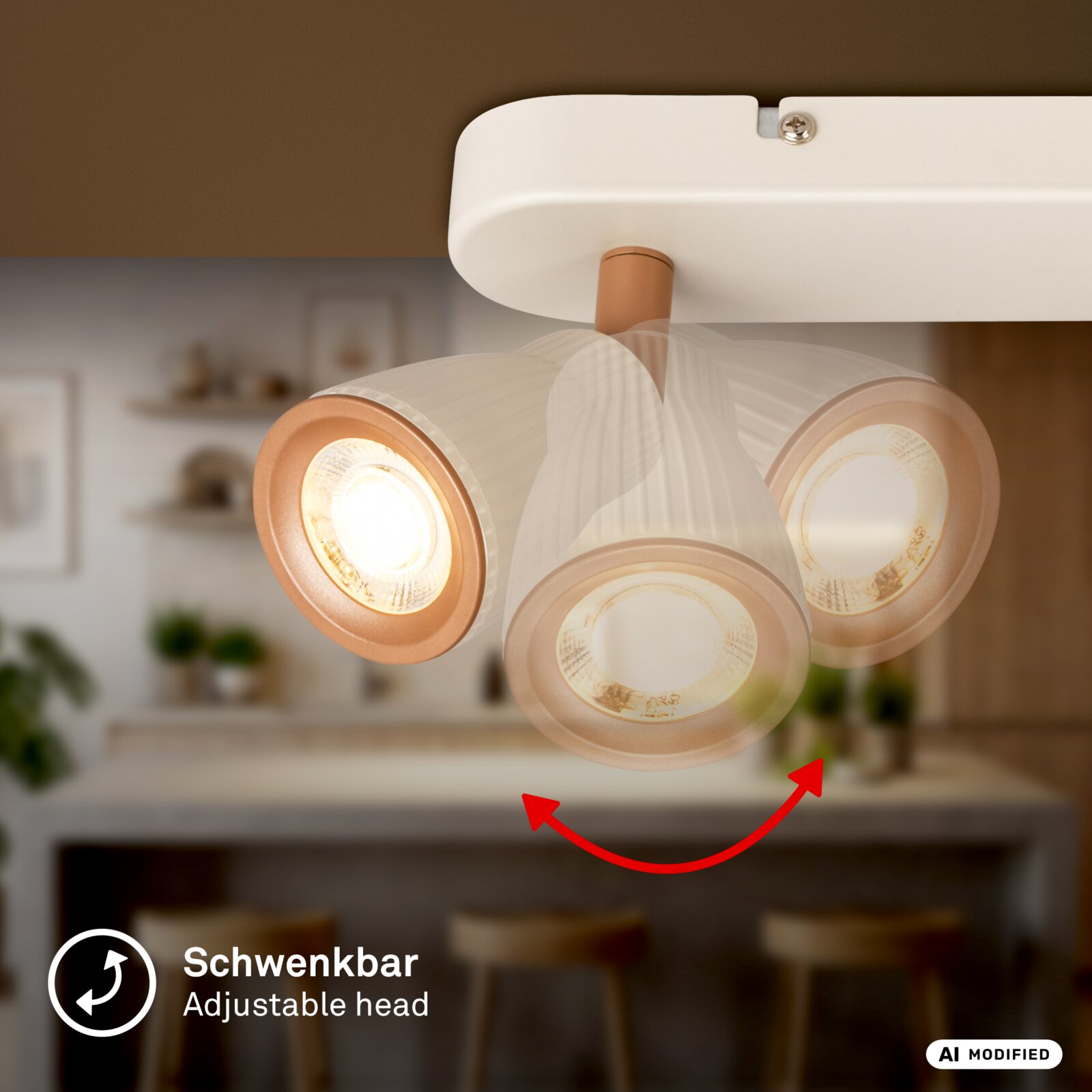 Schwenkbare Deckenleuchte mit drei Spotköpfen in Weiß und Roségold, eingeschaltet, Nahaufnahme von unten (Untersicht) vor unscharfem Küchenhintergrund.
