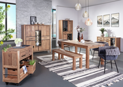 Esszimmer mit Holzmöbeln, darunter ein Esstisch, eine Bank, ein Servierwagen und ein Sideboard, aus der Perspektive von vorne links betrachtet.